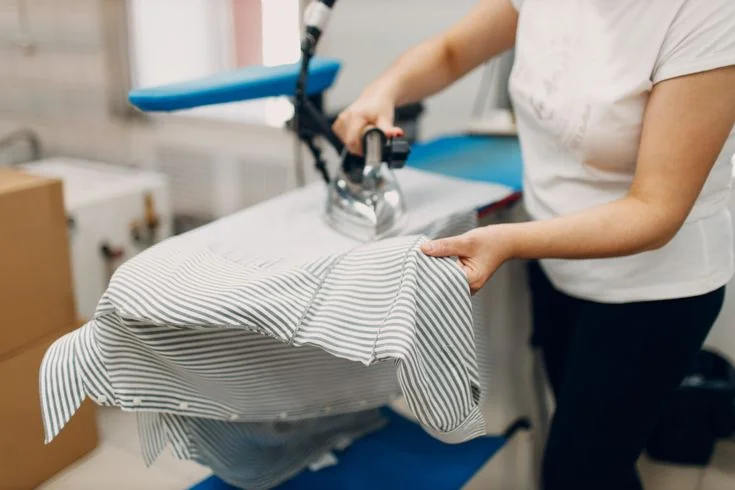 Repassage artisanal d'une chemise par une couturière Colblanc