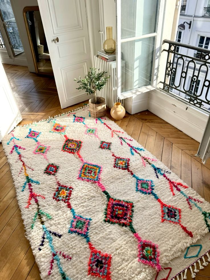 Tapis berbère blanc à motifs colorés dans un appartement haussmannien parisien